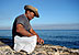 Pescador preparando la carnada en el muro del Malecón